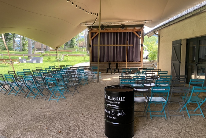 Espace extérieur aménagé pour une cérémonie ou un événement de groupe aux Murmures du Lignon.
