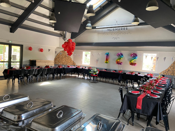 Salle de réception décorée de ballons rouges pour un anniversaire aux Murmures du Lignon à Tence.