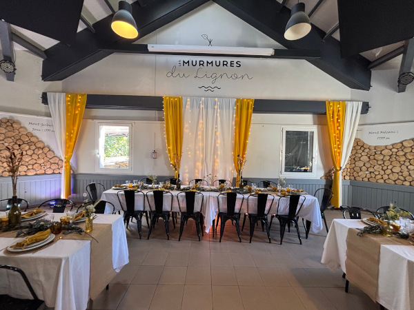 Salle de réception décorée avec tables dressées aux Murmures du Lignon à Tence en Haute-Loire.