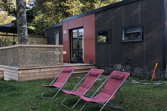 Chalet moderne avec terrasse en bois et transats pour un séjour nature à Tence en Haute-Loire.