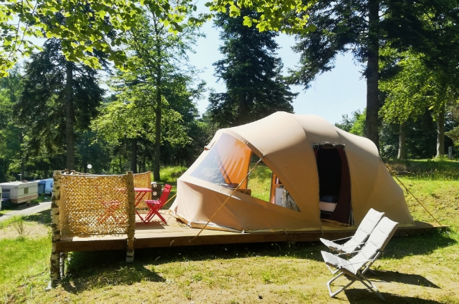 Tente aménagée avec terrasse en bois et mobilier extérieur pour des vacances nature à Tence.